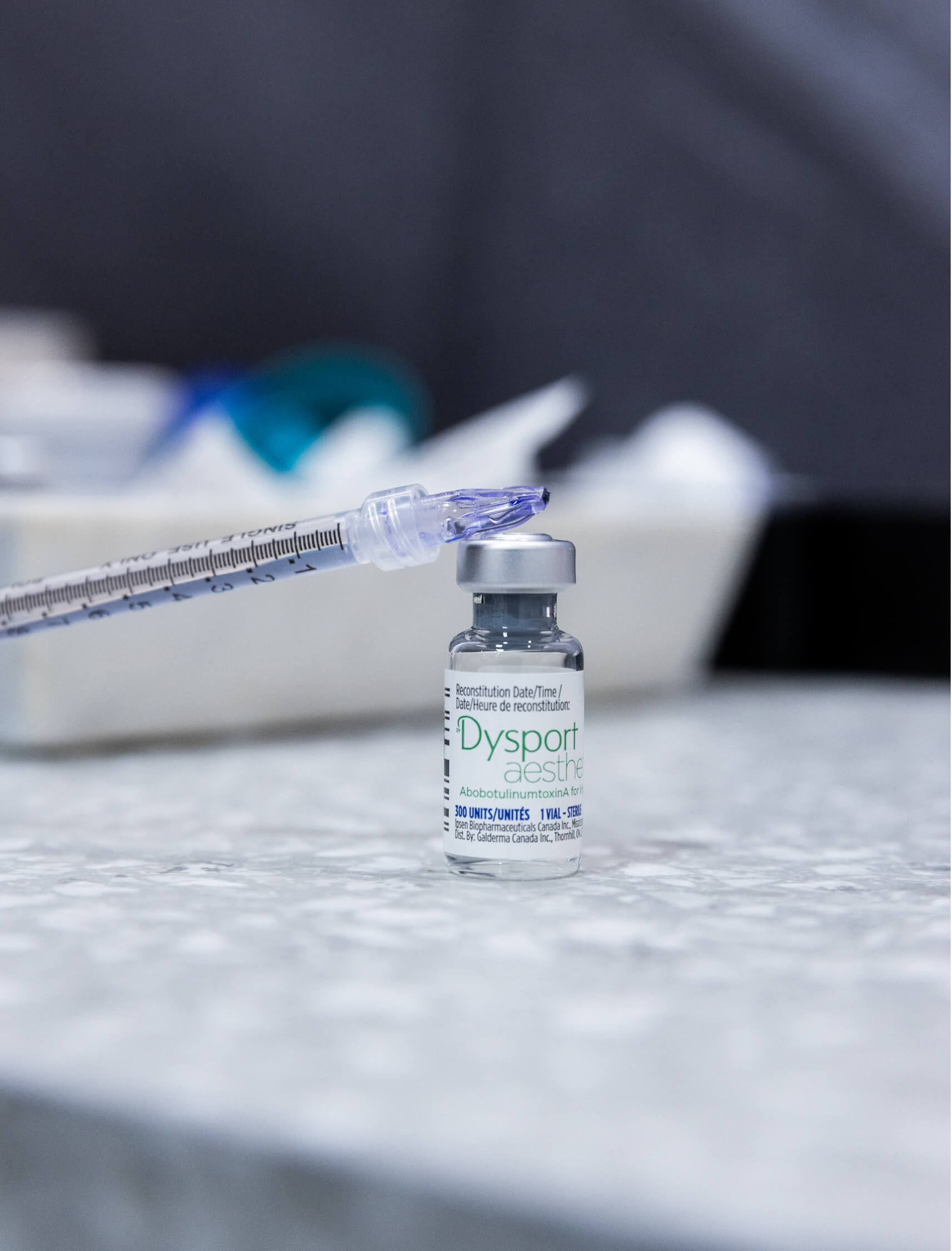 Seringue posée sur un flacon de toxine botulinique Dysport utilisée pour un traitement de type microtox.