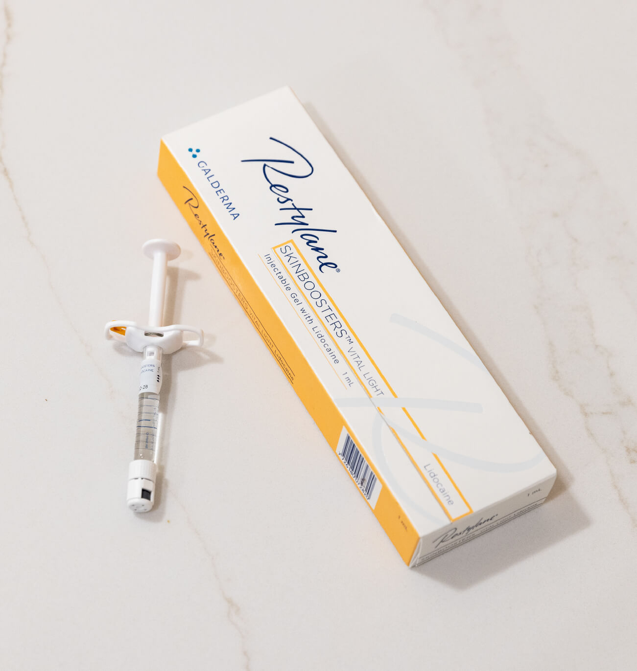 Boîte et seringue de Restylane Skinboosters Vital Light, un gel injectable utilisé pour hydrater la peau en profondeur et améliorer sa qualité.